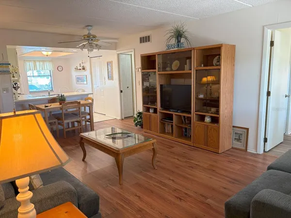 a living room with furniture a dining table and chairs with wooden floor