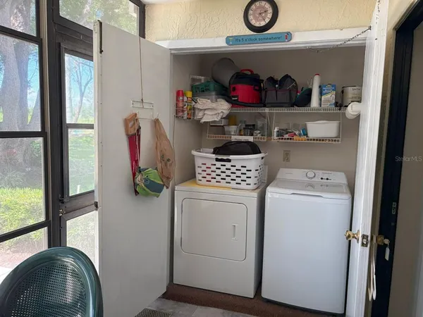 a utility room with fridge dryer and washer