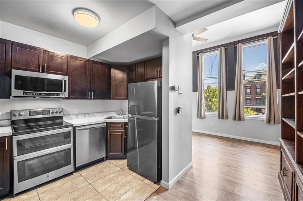 a kitchen with granite countertop a refrigerator and a stove top oven