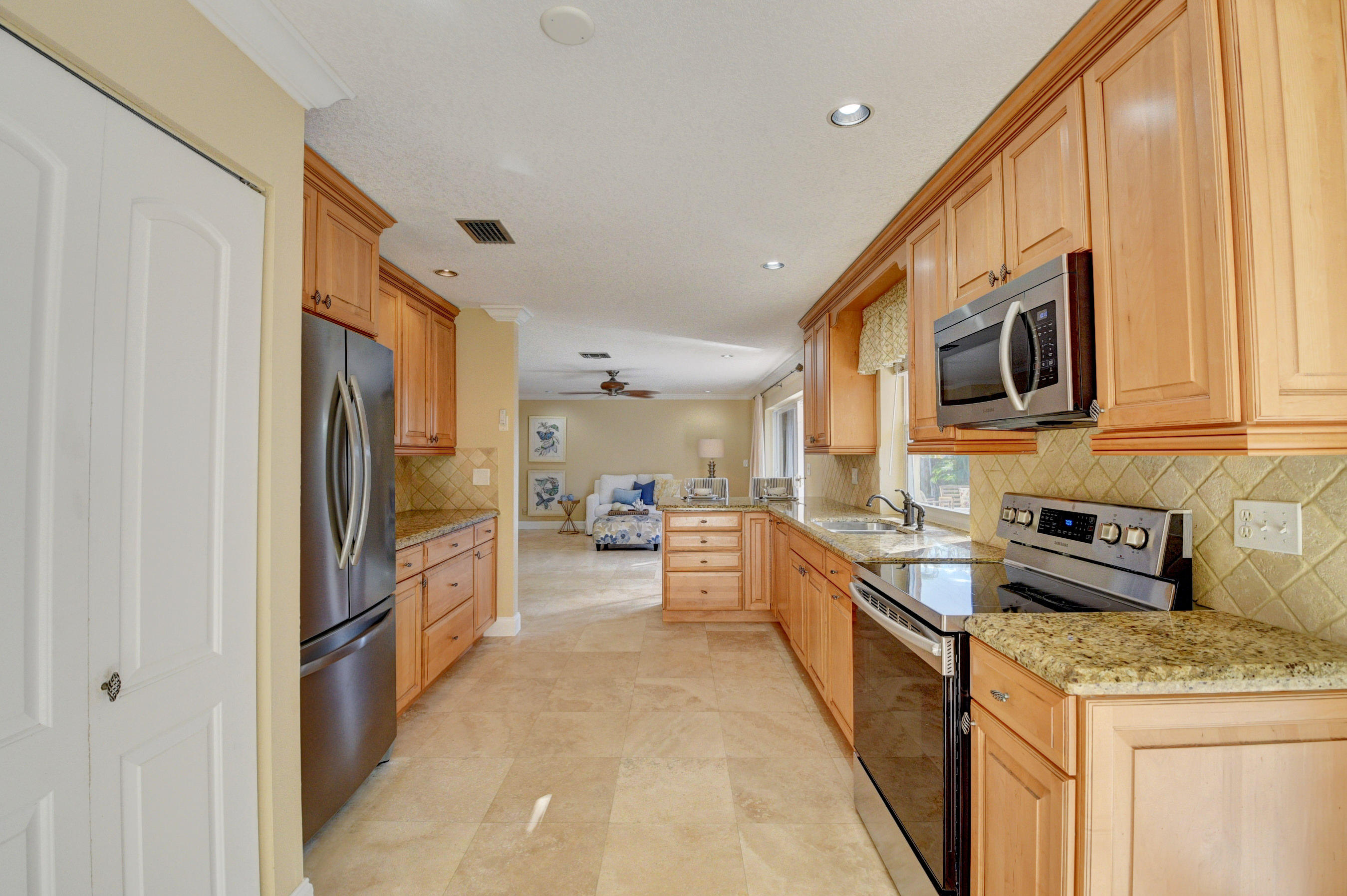 1990 Bonnie Street Boca Raton, FL 33486 - Photo 12 of 28 a kitchen with stainless steel appliances granite countertop a refrigerator a stove top oven a sink and dishwasher