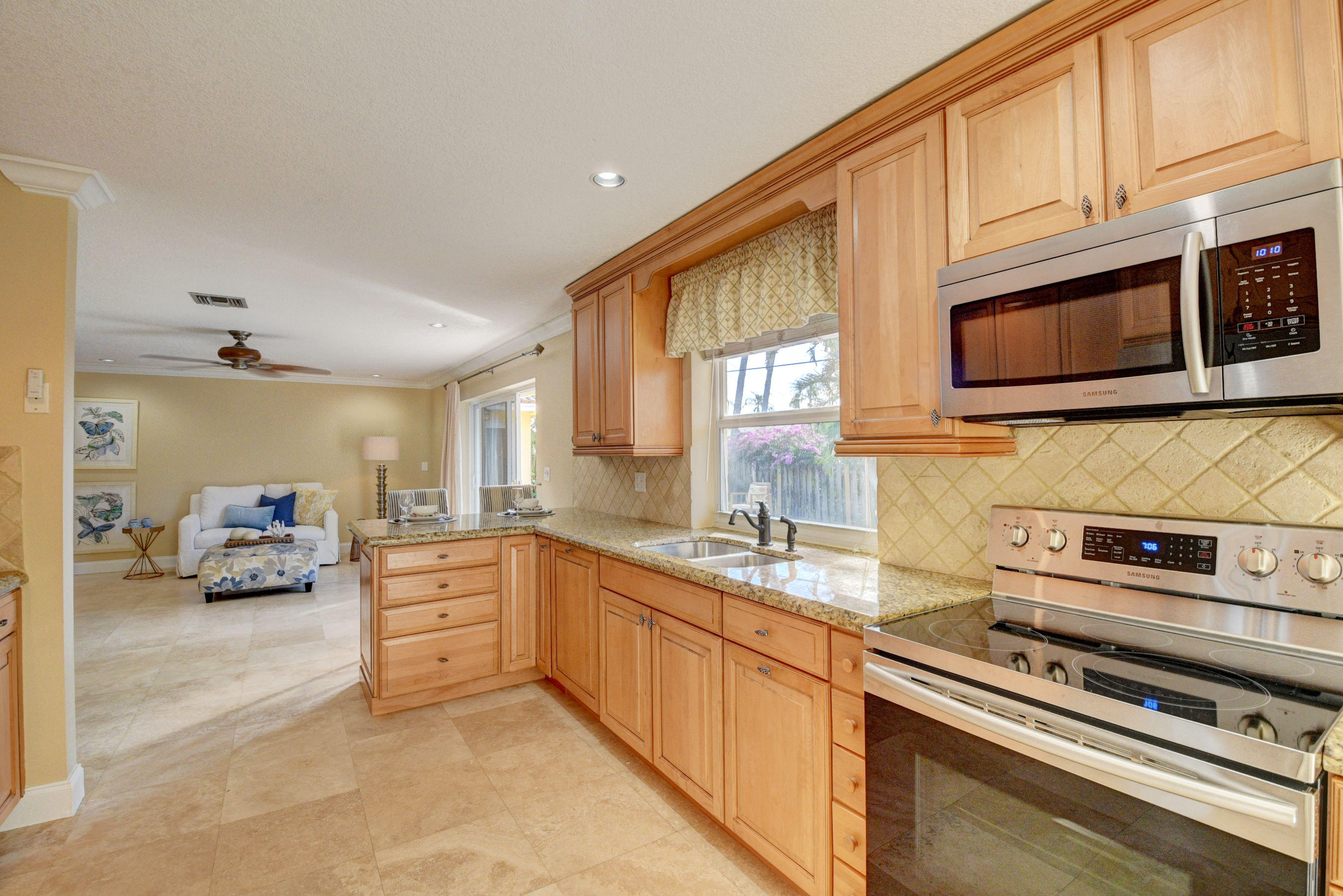 1990 Bonnie Street Boca Raton, FL 33486 - Photo 13 of 28 a kitchen with stainless steel appliances granite countertop a stove sink and cabinets