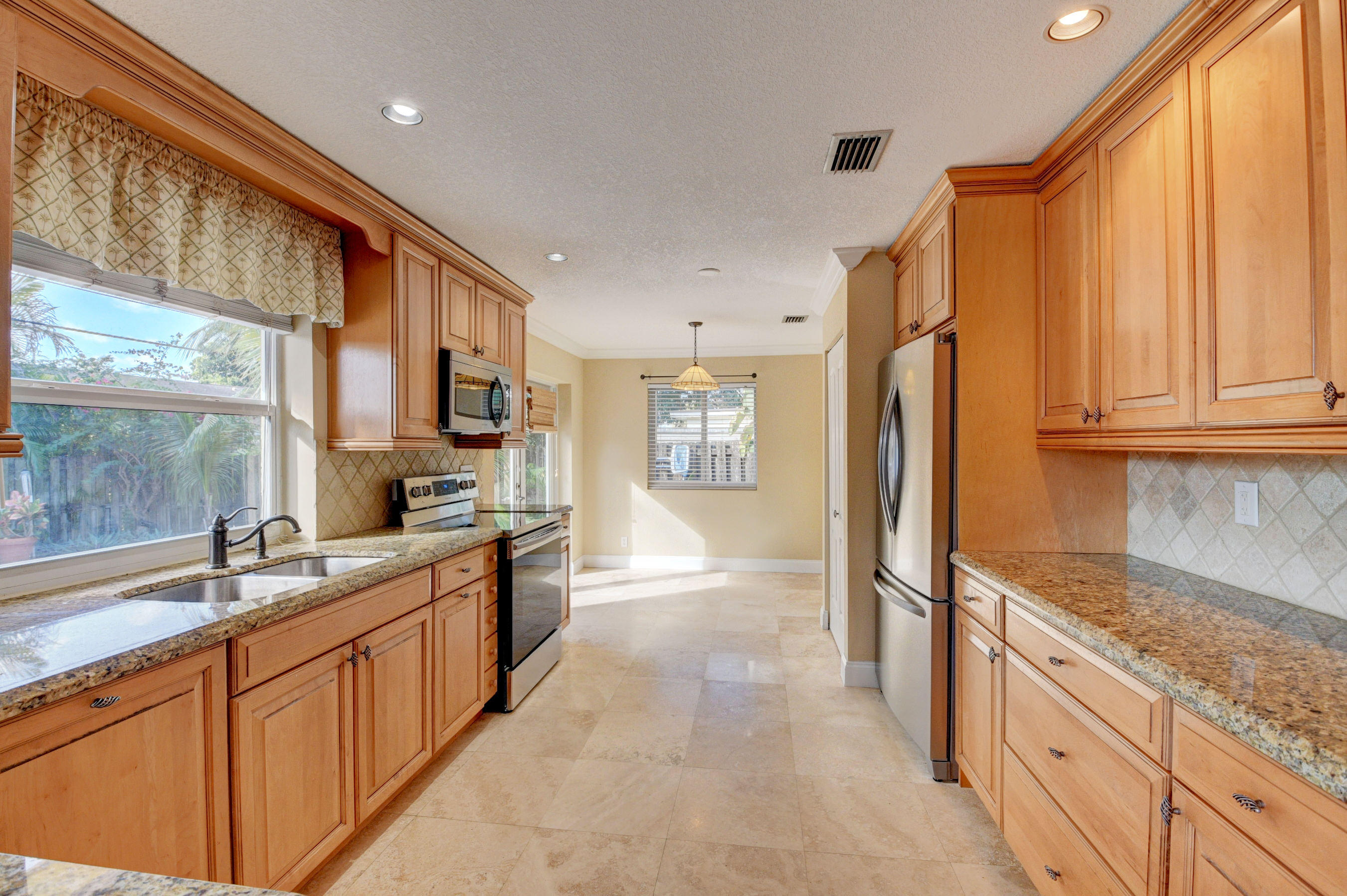1990 Bonnie Street Boca Raton, FL 33486 - Photo 14 of 28 a large kitchen with stainless steel appliances granite countertop a refrigerator and a sink