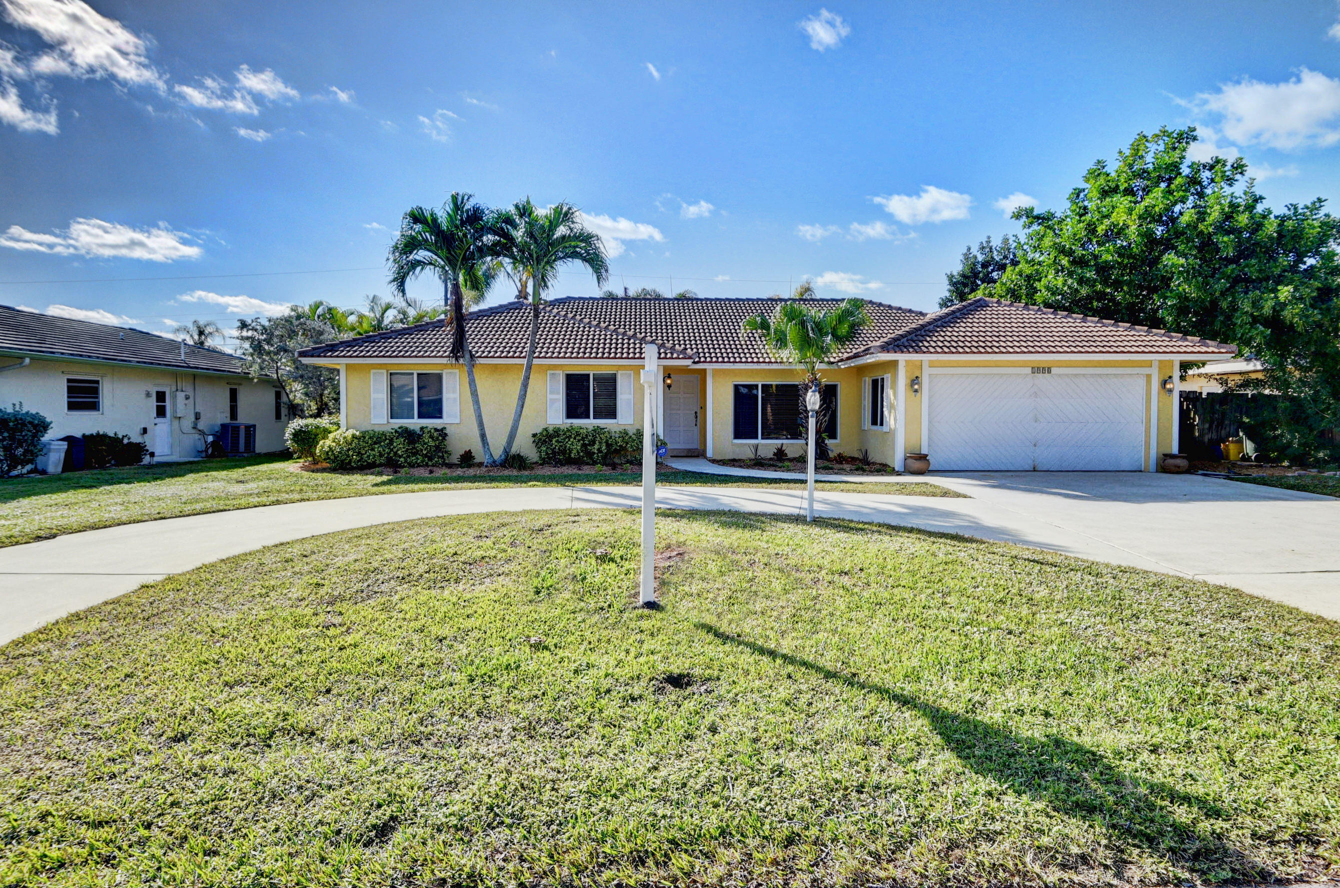 1990 Bonnie Street Boca Raton, FL 33486 - Photo 2 of 28 a front view of a house with a yard table and chairs