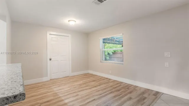 a kitchen with stainless steel appliances granite countertop a refrigerator and white cabinets