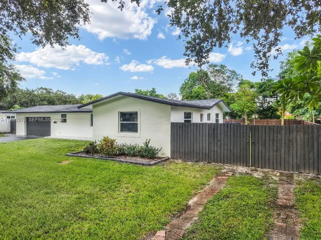 a view of backyard of house with green space