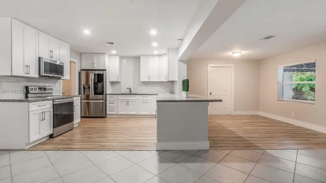 a kitchen with stainless steel appliances granite countertop a refrigerator sink and cabinets