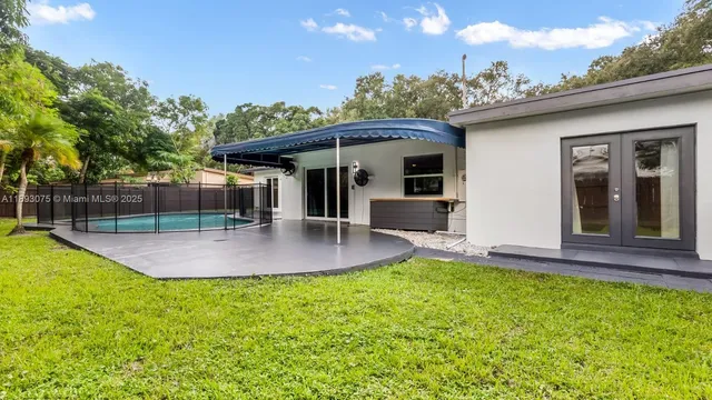 a view of a house with a backyard and a patio