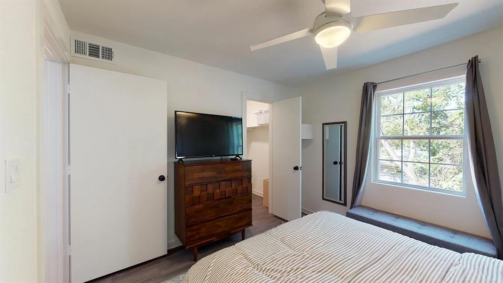 321 East 8th Street, Unit 104 Dallas, TX 75203 - Photo 8 of 15 a bedroom with a bed and a flat screen tv