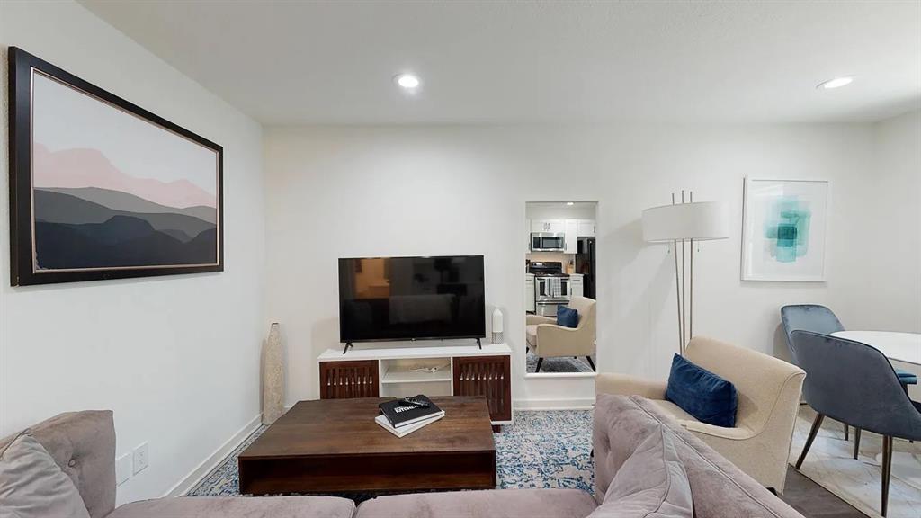 321 East 8th Street, Unit 104 Dallas, TX 75203 - Photo 9 of 15 a living room with furniture and a flat screen tv