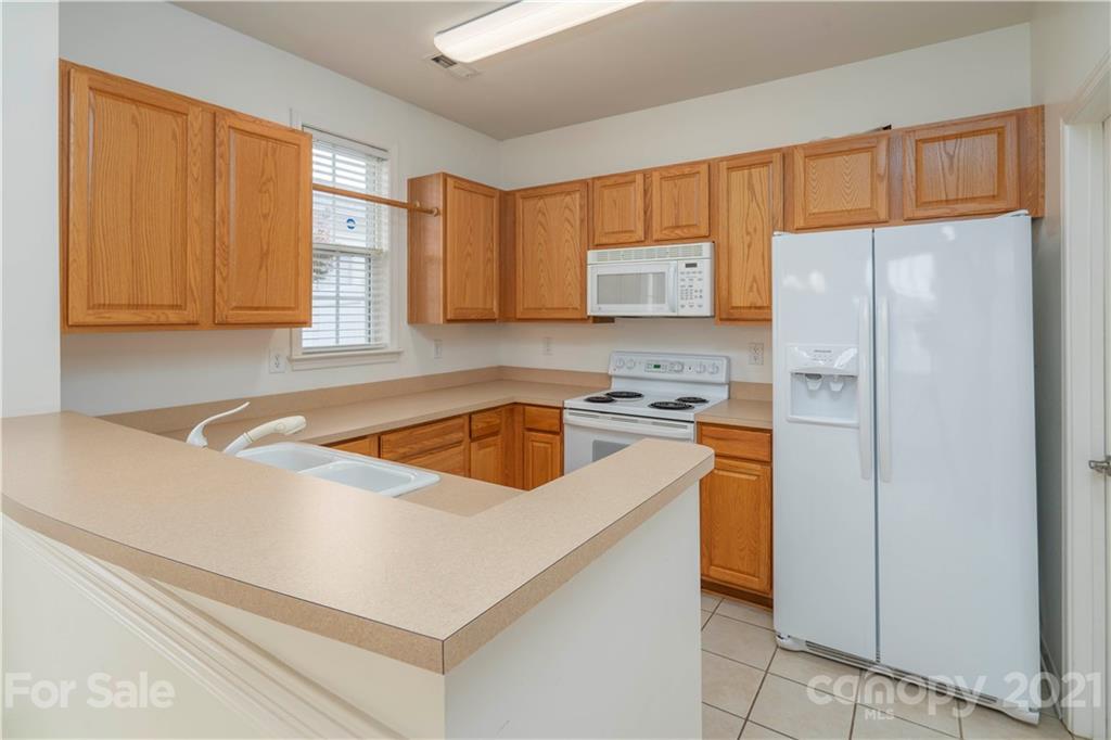 652 Old Meeting Way Davidson, NC 28036 - Photo 14 of 32 a kitchen with stainless steel appliances granite countertop a refrigerator sink and stove