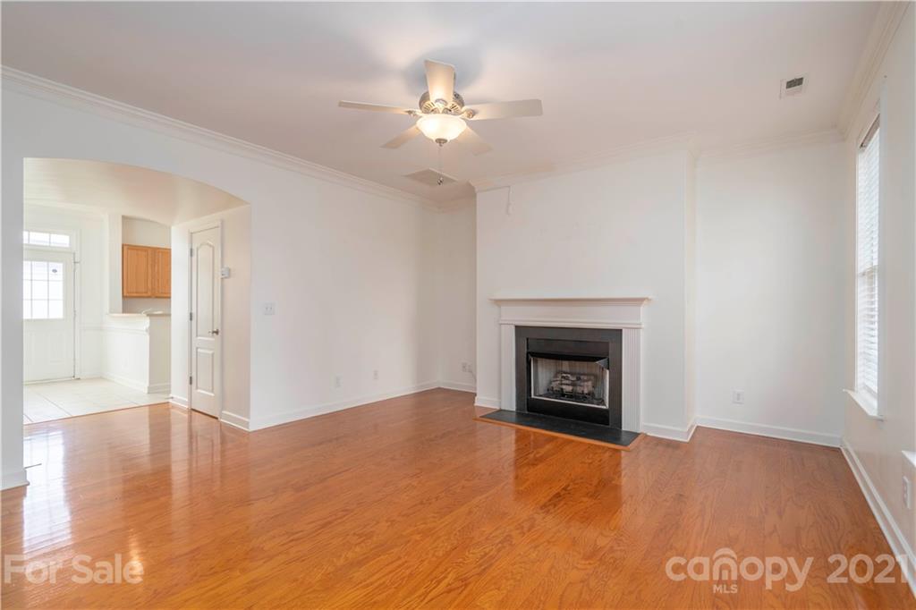 652 Old Meeting Way Davidson, NC 28036 - Photo 6 of 32 a view of an empty room with wooden floor fireplace and a window