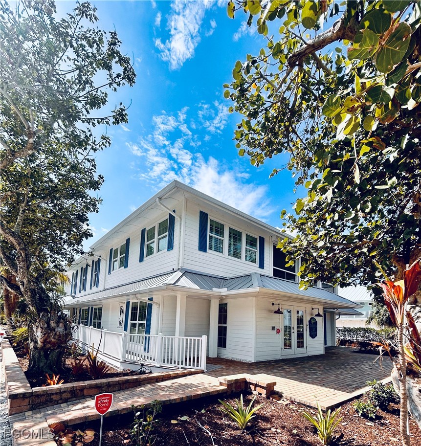 a front view of a house with a tree