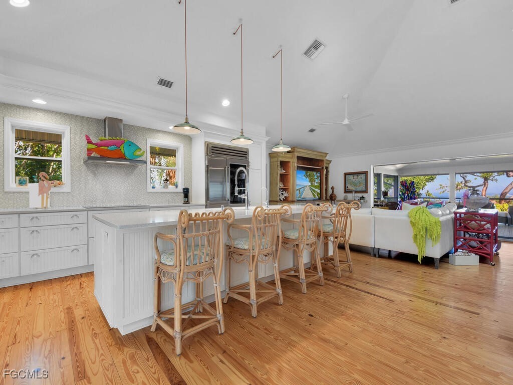 8315 Main Street Bokeelia, FL 33922 - Photo 17 of 50 a kitchen with stainless steel appliances kitchen island granite countertop a table chairs and a refrigerator