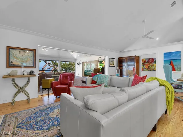 a living room with furniture kitchen view and a chandelier