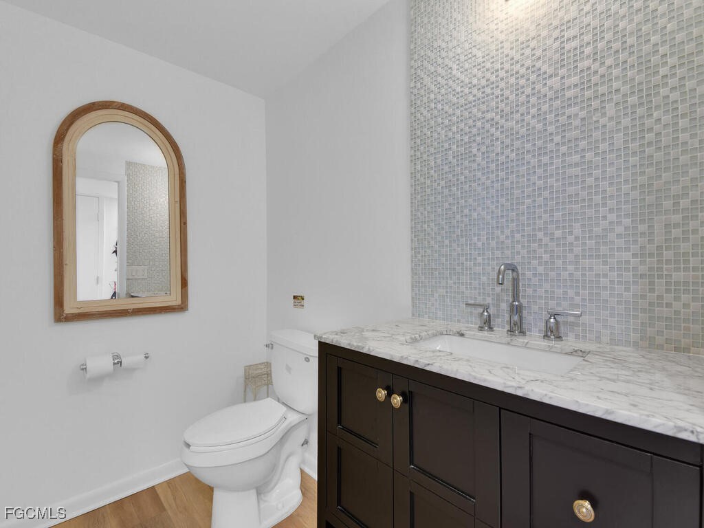 8315 Main Street Bokeelia, FL 33922 - Photo 36 of 50 a bathroom with a granite countertop sink and a toilet