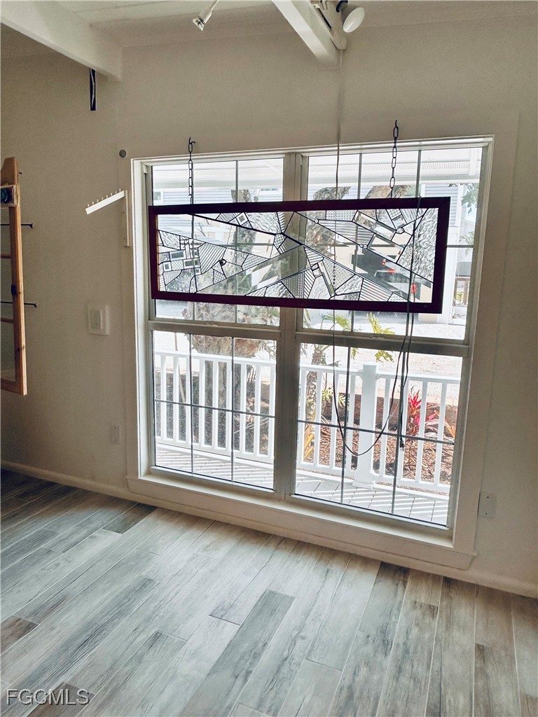 8315 Main Street Bokeelia, FL 33922 - Photo 10 of 50 a view of an empty room with wooden floor and a window