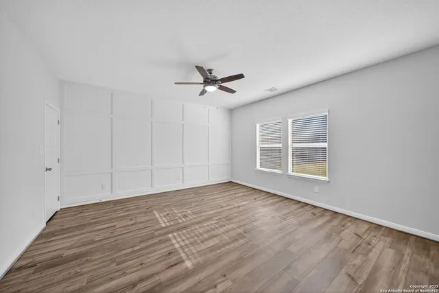 a view of a livingroom with a ceiling fan and wooden floor