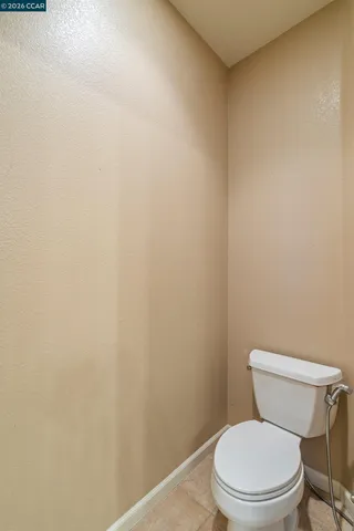 a bathroom with a granite countertop toilet a sink and a mirror