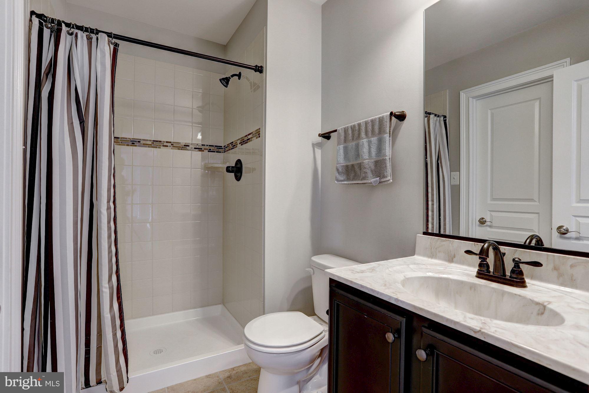 8420 High Ridge Road Ellicott City, MD 21043 - Photo 12 of 30 a bathroom with a granite countertop sink toilet and shower