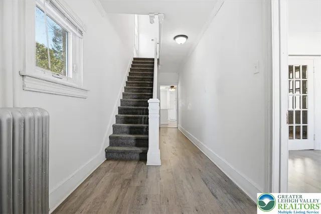 a kitchen with stainless steel appliances granite countertop a sink a stove a refrigerator and island with wooden floor