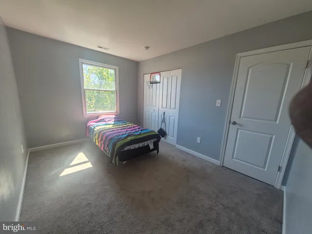 a bed sitting in a bedroom next to a window