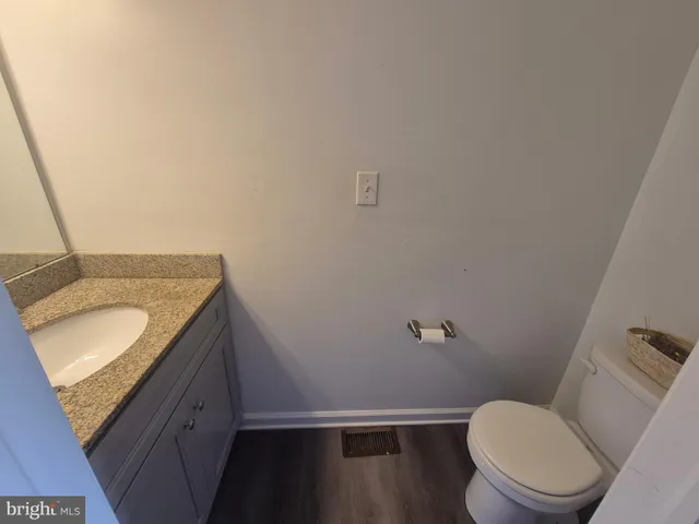 a bathroom with a granite countertop toilet and sink