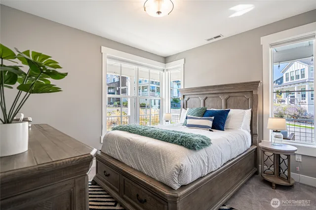 a bedroom with a bed and a potted plant on the dresser