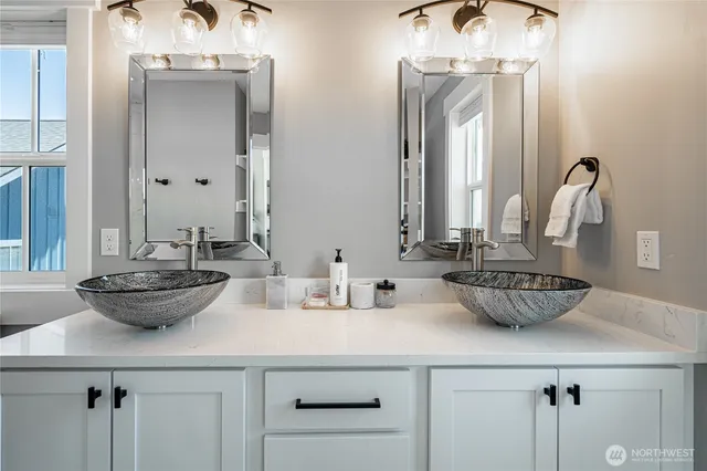 a bathroom with a double vanity sink and a mirror