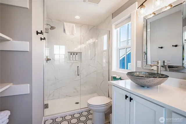 a bathroom with a sink a toilet and shower