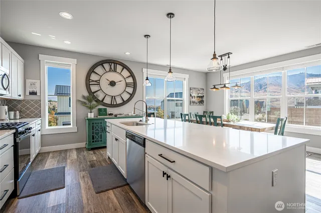a large kitchen with kitchen island a large counter space a sink appliances and living room view