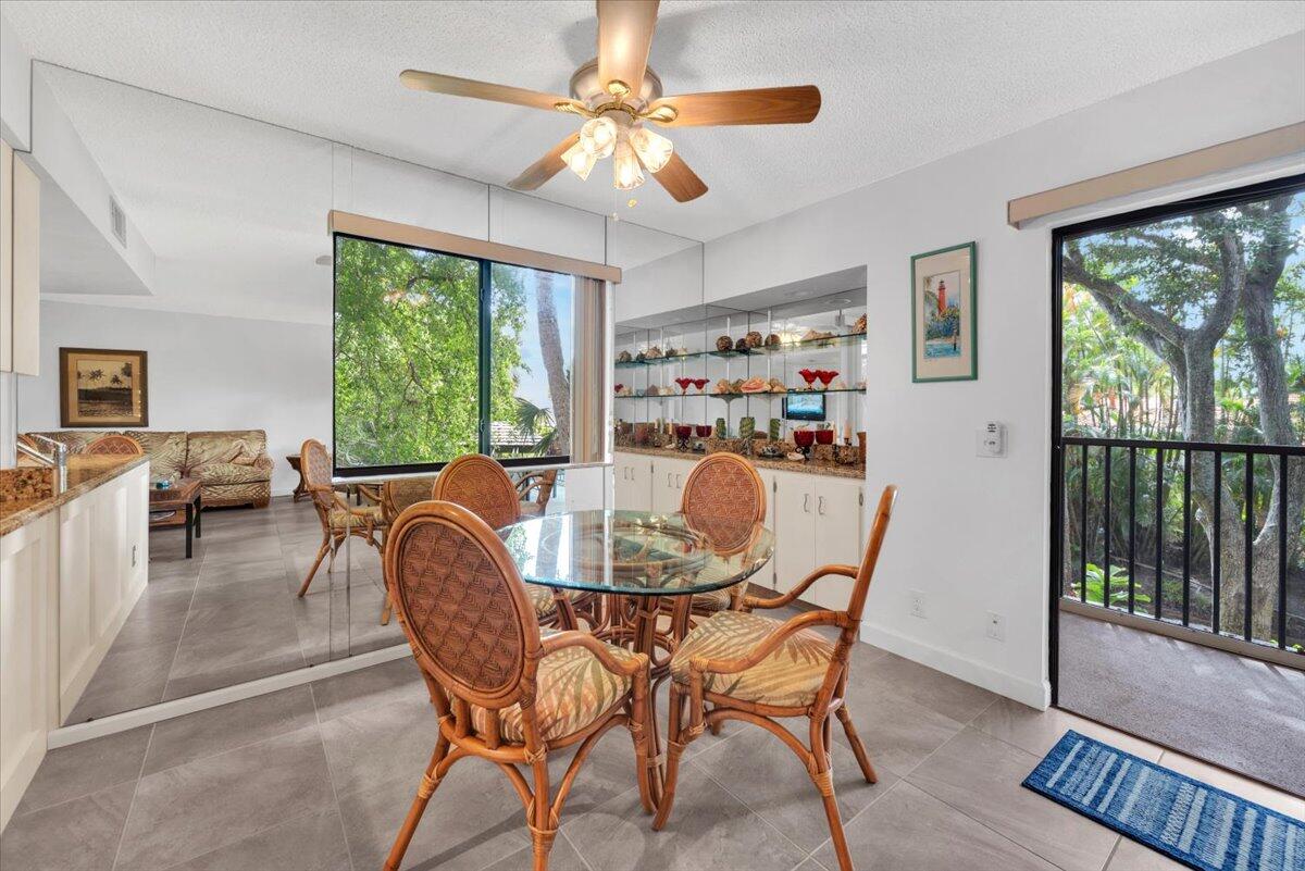 1605 Highway 1, Unit E201 Jupiter, FL 33477 - Photo 11 of 19 a dining room with furniture a chandelier and wooden floor