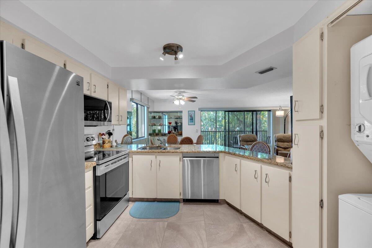 1605 Highway 1, Unit E201 Jupiter, FL 33477 - Photo 14 of 19 a kitchen with appliances a sink and cabinets