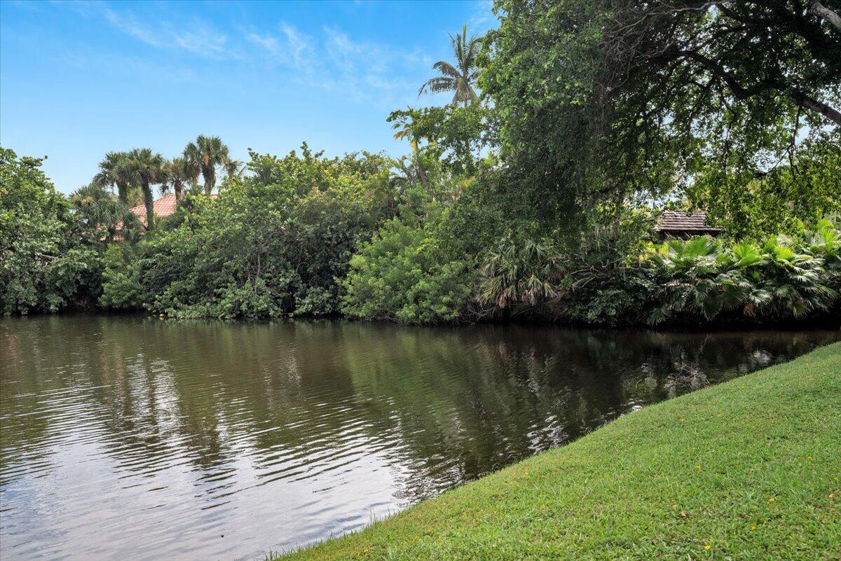 1605 Highway 1, Unit E201 Jupiter, FL 33477 - Photo 4 of 19 a view of a lake with a yard and trees in the background