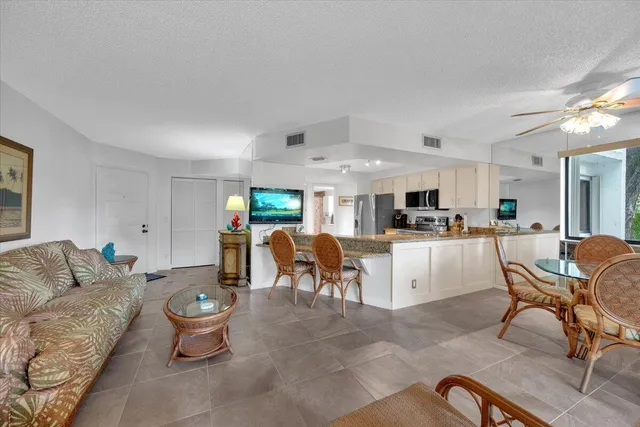a living room with furniture a dining table and kitchen view