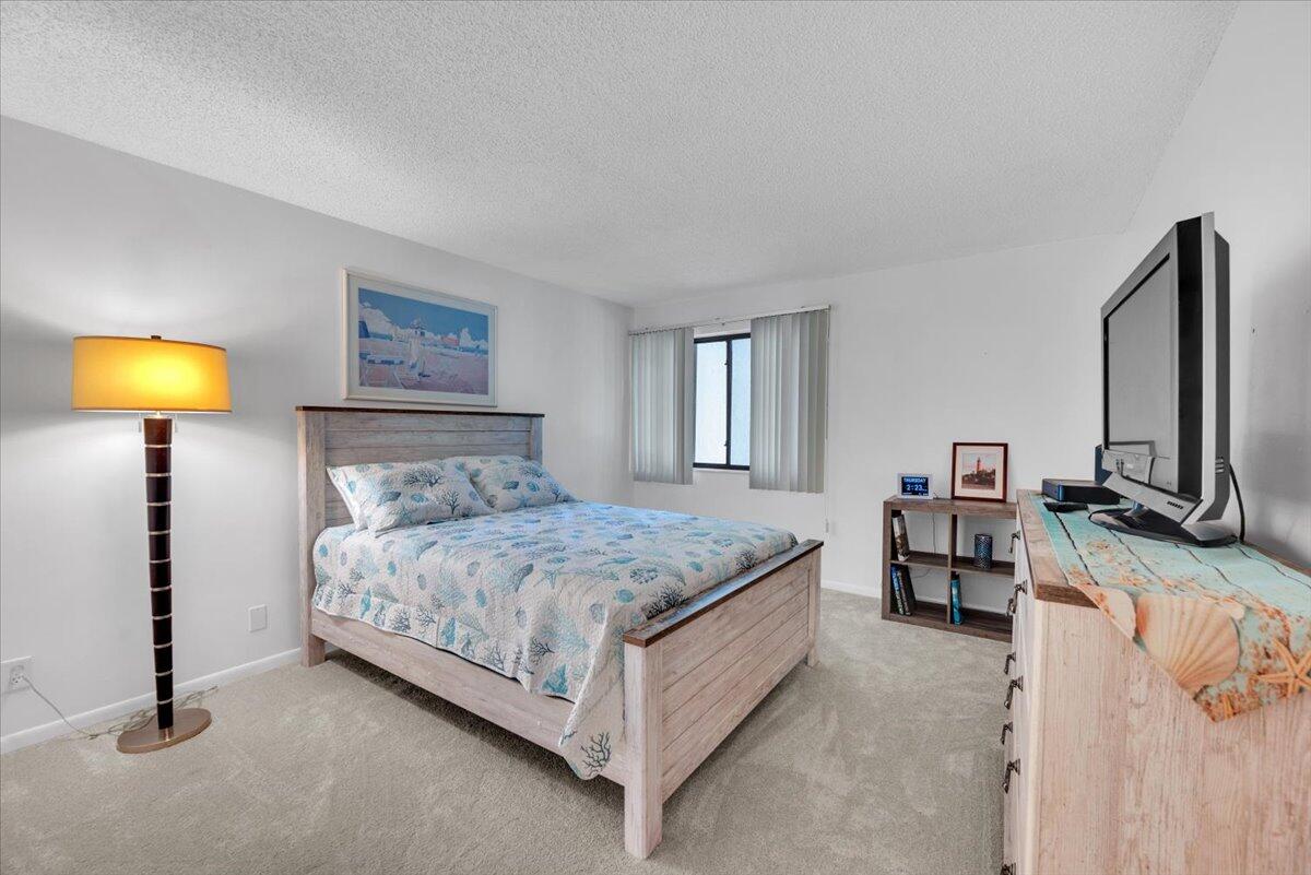 1605 Highway 1, Unit E201 Jupiter, FL 33477 - Photo 7 of 19 a bedroom with a bed and a lamp