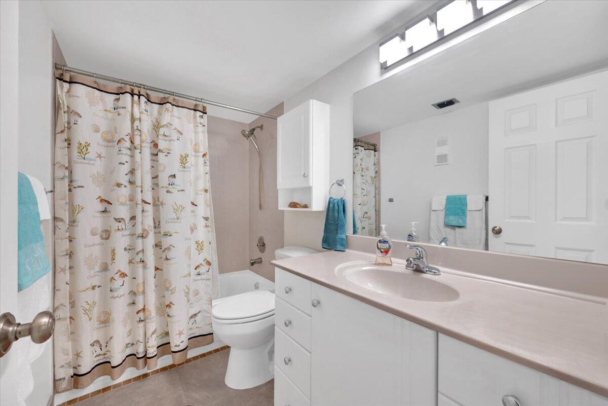 1605 Highway 1, Unit E201 Jupiter, FL 33477 - Photo 8 of 19 a bathroom with a double vanity sink toilet and shower