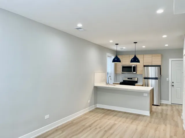 a large white kitchen with a sink a microwave and cabinets