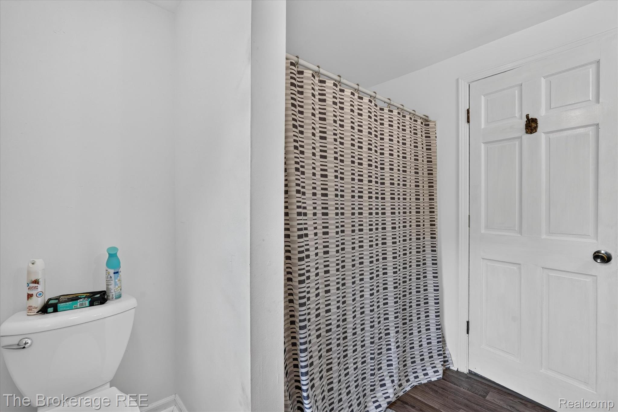13269 North Genesee Road Clio, MI 48420 - Photo 37 of 67 Bathroom featuring a white paneled door, wood-finish flooring, and white walls