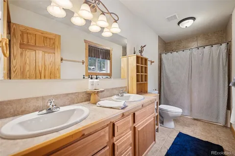 a bathroom with a double vanity sink toilet and shower