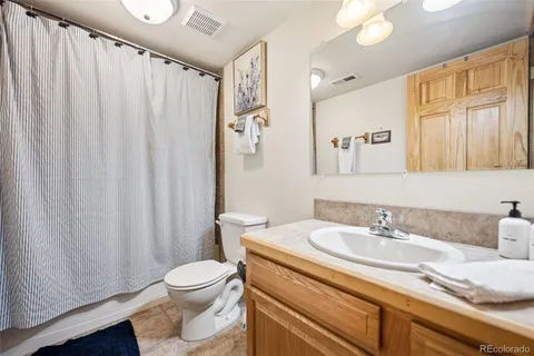 a bathroom with a granite countertop sink toilet and a mirror