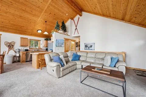 a living room with furniture and kitchen view