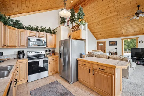 a kitchen with stainless steel appliances granite countertop a sink a stove and a refrigerator