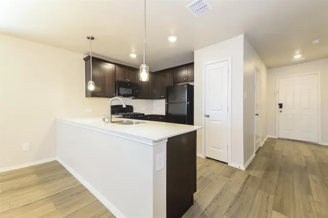 a kitchen with kitchen island a sink stainless steel appliances and cabinets