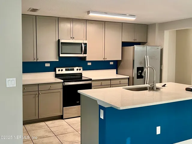 a kitchen with a sink a stove and refrigerator