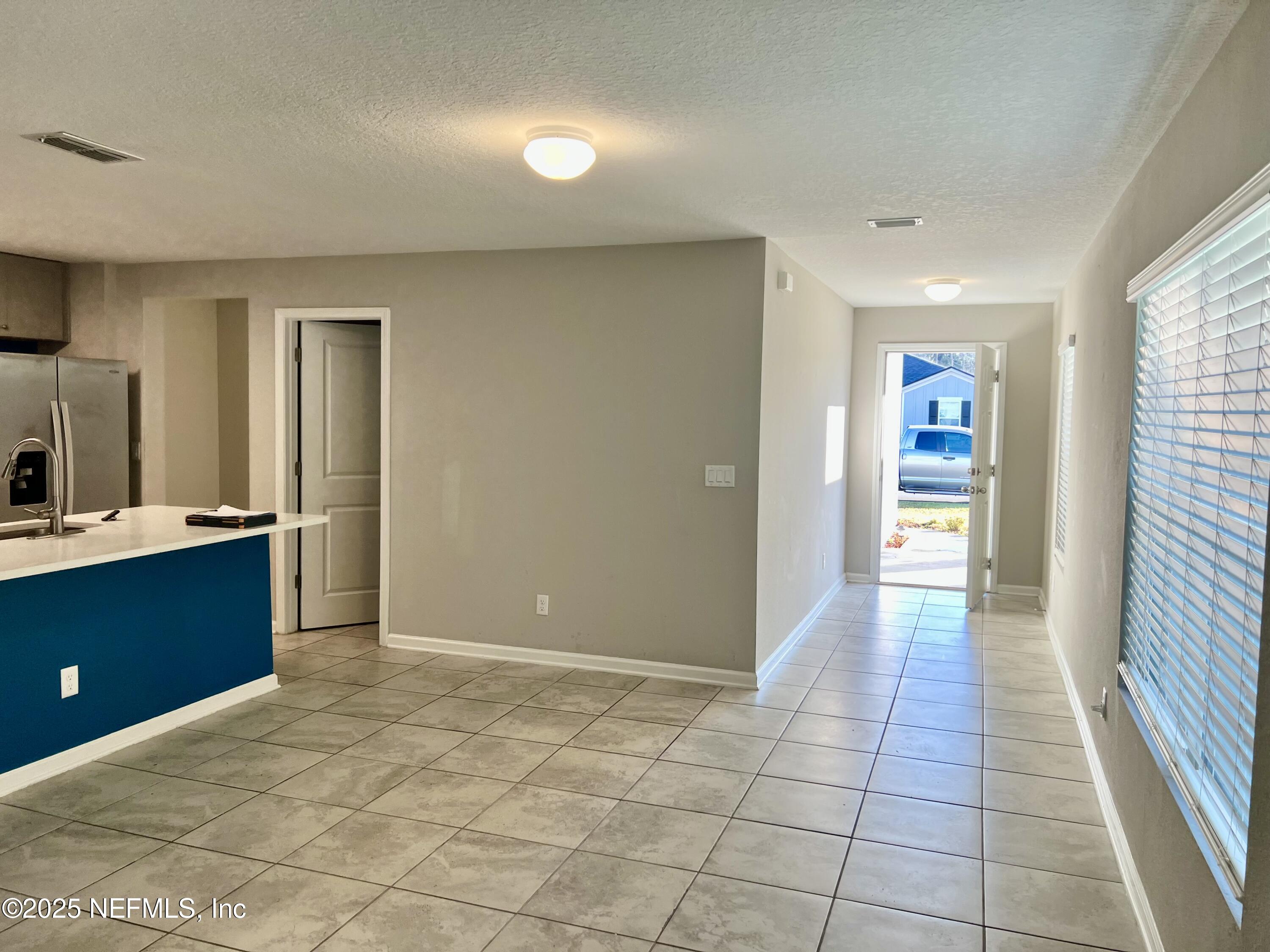 11630 Palladio Way Jacksonville, FL 32218 - Photo 7 of 23 a view of a hallway and an empty room with wooden floor and a window