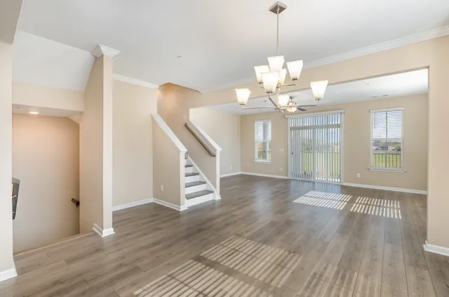 a view of a livingroom with wooden floor and a chandelier