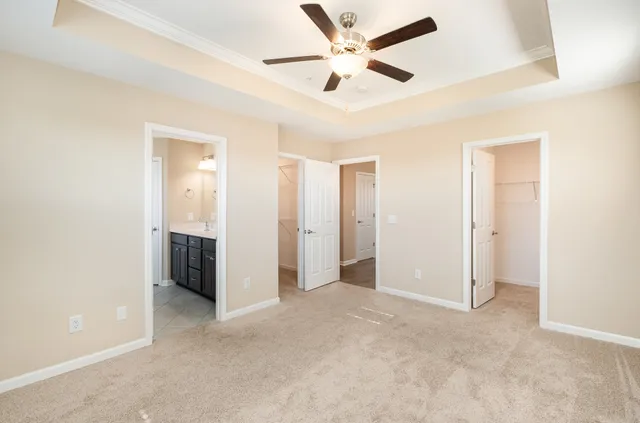 an empty room with closet and a ceiling fan