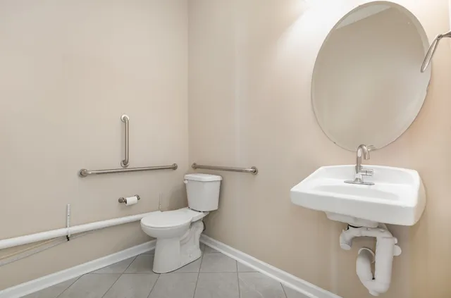 a bathroom with a sink a toilet and a mirror