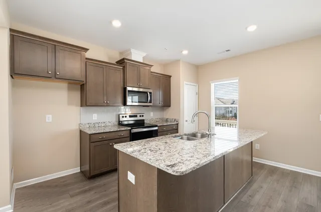 a kitchen with stainless steel appliances granite countertop a sink stove and refrigerator
