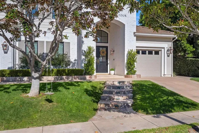 a front view of a house with a garden and plants